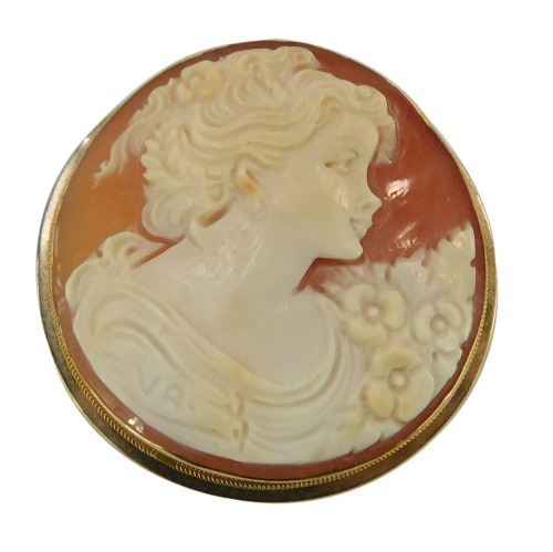 A 9ct gold framed cameo pendant, the circular pendant with raised figure of a female with flowers, with brooch and pendant back, 4cm wide.