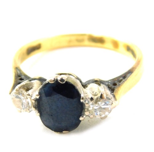 An 18ct gold sapphire and diamond dress ring, the oval sapphire in claw setting, flanked by two diamonds, each approx 0.15ct, size N, 3.9g all in.