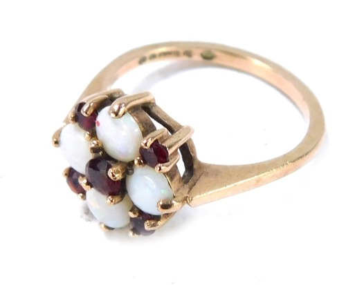A 9ct gold opal and garnet cluster ring, with four circular cut opals, an arrangement of garnets in claw setting on raised basket, size M&frac12;, 2.6g all in.
