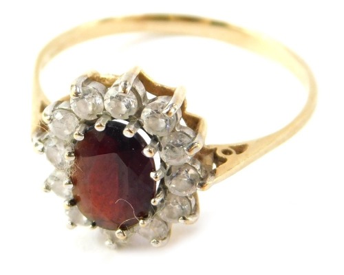 A 9ct gold floral cluster ring, with garnet and CZ stones, raised scroll shoulders, size S&frac12;, 2.5g all in.