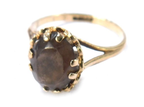 A 9ct gold smoky quartz dress ring, the oval smoky quartz with fluted outer border, on three strand V splayed shoulders, size O&frac12;, 2.2g all in.