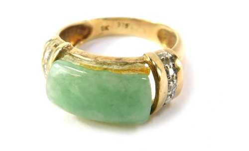 A jade and diamond dress ring, the oblong jade central stone with diamond set shoulders, yellow metal stamped 9k, size I&frac12;, 3.3g all in.