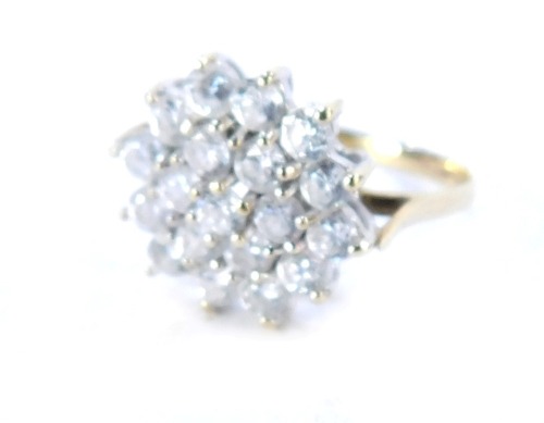 A 9ct gold cluster ring, the cluster ring set with imitation diamonds over three layers, in a raised basket setting, on thin band, size K, 2.5g all in.