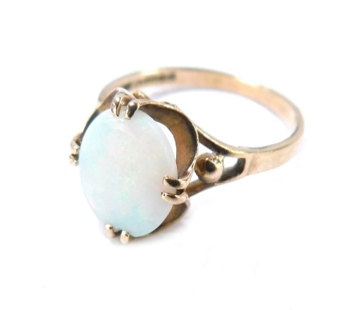 A 9ct gold opal dress ring, the oval opal in four twin claw setting, with fluted border and pierced design shoulders, size N&frac12;, 2.1g all in, boxed.