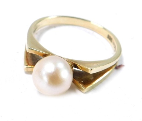A cultured pearl dress ring, the central pearl with two bow design shoulders, size N&frac12;, 3.5g all in, boxed.
