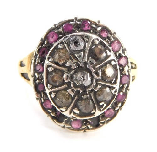 An 18ct gold dress ring, the large oval centre set with various rubies and diamonds, with etched design V splayed shoulders and later matched ring head, ring size Q&frac12;, 4.3g all in, boxed.