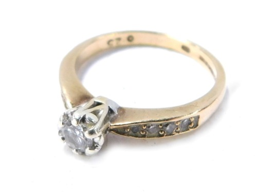 A 9ct gold diamond solitaire ring, with round brilliant cut claw set diamond, approx 0.10cts, with three tiny diamond set shoulders, size I&frac12;, 2g all in.