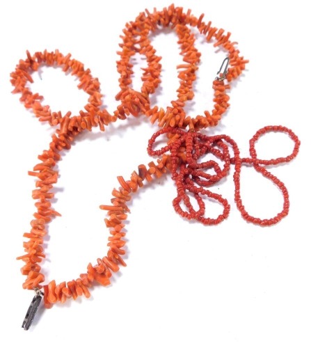 Two coral necklaces, comprising a two strand coral choker, with silver plated clasp, 40cm long, and a single strand dark coral neck chain, 66cm long. (2)
