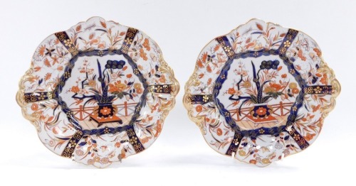 A pair of early 19thC Masons ironstone dessert dishes, of twin handled, lobed hexagonal form, imari decorated with a central panel of flowers in an urn, within border panels of birds and flowers, gilt heightened, printed marks, 24.5cm wide.