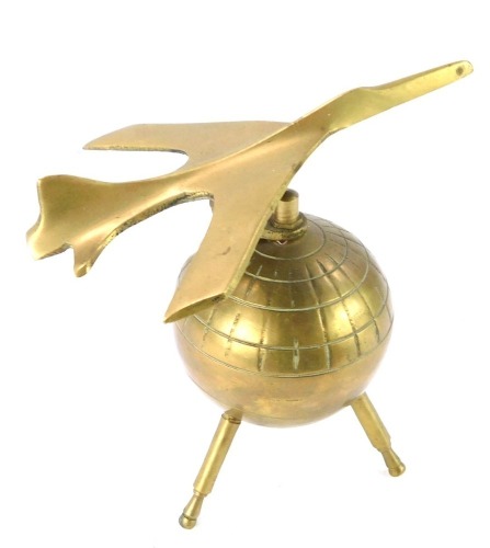 A retro brass desk weight, modelled as a jet plane atop a Sputnik globe, 12.5cm wide.