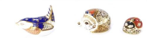Three Royal Crown Derby paperweights, comprising Hedgehog, Signature edition of 1500 for Goviers of Sidmouth, 4cm high, with gold stopper, Ladybird with gold stopper, 3cm high, and a Wren with gold stopper, 5cm high, with two unmatched boxes. (5)