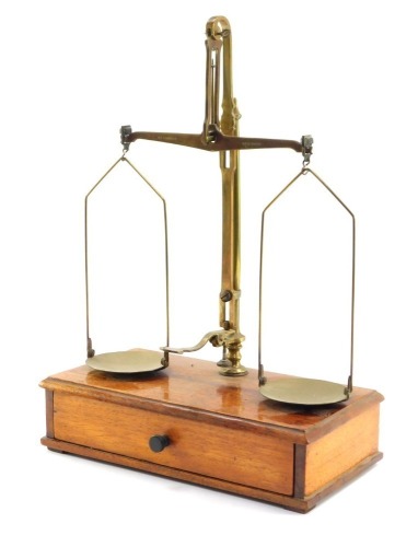 A set of early 20thC brass chemist scales, the balance marked W & T Avery Ltd Birmingham, on a mahogany base on a single pull out drawer, with weights, 37cm high, 26cm wide, 12cm deep.