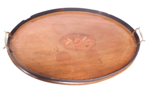 An Edwardian mahogany twin handled oval serving tray, the oval tray with central rose inlay, with brass handles, 60cm diameter.