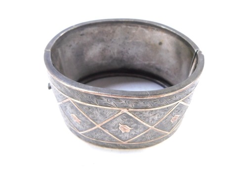 A Victorian silver hinged cuff bangle, of bicoloured design, with square set panels with tulips, 6.5cm diameter, 45g all in.