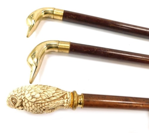 Three walking canes, comprising a resin handled owl cane and two brass duck headed walking canes. (3)