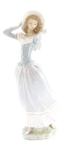 A Lladro porcelain figure of a lady in flowing dress, on a windy day, 36cm high.