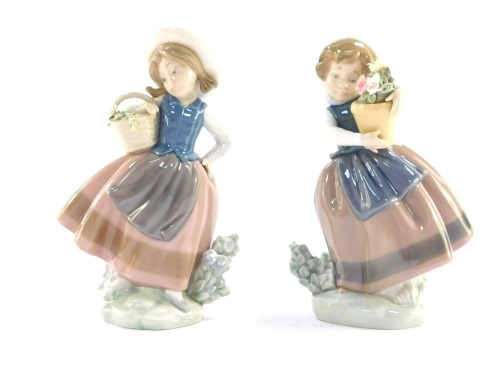 Two Lladro figures, each with a girl carrying a basket of flowers, both 16cm high.
