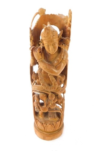 Tribal Art. A carved wooden figure of a Bodhisattva, modelled on a lotus flower, 29cm high.