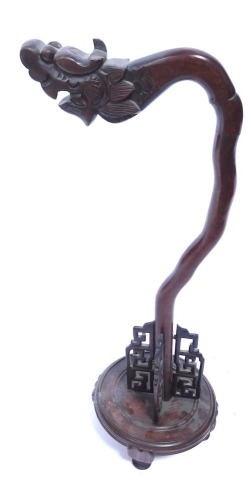 A Middle Eastern hardwood lamp stand, with dragon arch top, on a circular base, 60cm high.