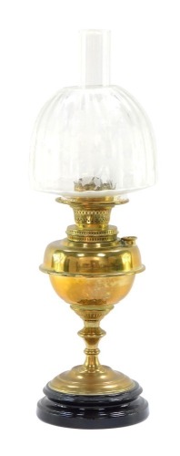 A Victorian brass oil lamp, with a pleated glass shade, floral applied detail on brass reservoir, on ebonised base, 62cm high.