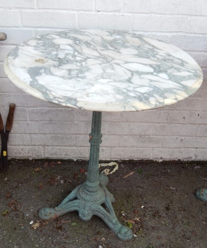 A cast iron and marble topped pub table, the circular marble top on a green cast iron tripod base, 70cm high, 62cm diameter.