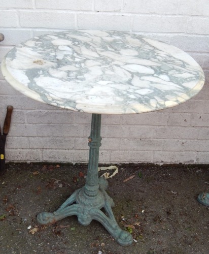 A cast iron and marble topped pub table, the circular marble top on a green cast iron tripod base, 70cm high, 62cm diameter.