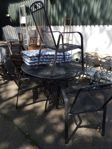 A metal circular garden table and four chairs, the chairs having flower crest top, table 70cm high, 120cm diameter, with a small group of seat cushions.
