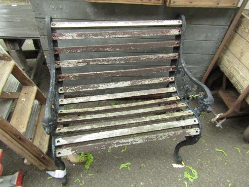 A cast iron ended slatted garden bench, the metal ends painted in black with lion masks, wooden slat seat, 88cm high, 81cm wide, 60cm deep.