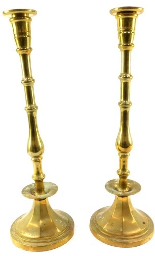 A pair of brass altar candlesticks, each on a tapered stem on circular foot, 49cm high.