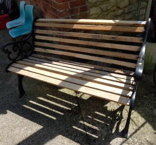 A slatted garden bench, with painted black metal ends, 78cm high, 132cm wide, 56cm deep.