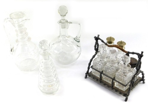 An early 19thC glass spirit decanter and stopper, of graduated seven ring form, 22cm high, together with a late 19thC cut glass claret jug, with a triple ring collar and mushroom shape stopper, 26cm high, further cut glass claret jug and stopper, and a Vi