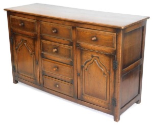An oak dresser, with arrangement of two cupboard doors and two drawers, and central four drawer section, one handle lacking, 91cm high, 152cm wide, 52cm deep.
