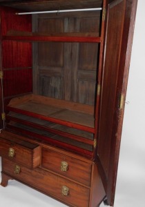 A George III flame mahogany linen press, with moulded cornice over two radiating flamed panel doors, enclosing an interior with an arrangement of press drawers and an optional hanging space, over two short and one long deep drawer, with heavy brass mask h - 2