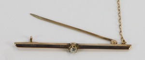 A diamond set bar brooch, with single round brilliant cut diamond, in claw setting on yellow metal bar, with safety chain, unmarked, the diamond approx 0.05 points, 6cm wide, 3.7g all in. - 2