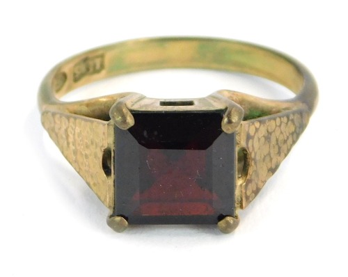A dress ring, set with square cut garnet on bark effect shoulders in claw setting, ring size M&frac12;, yellow metal, stamped 9ct, 3.3g all in.