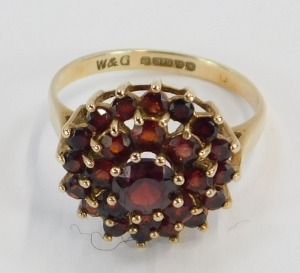A 9ct gold garnet cluster ring, with three layers of garnets each in a raised basket claw setting, ring size M, 2.9g all in. - 2