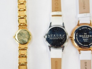 A group of lady's wristwatches, to include a Skagen chronograph on white leather strap, a Skagen stainless and red material strapped bracelet, a Skagen gold plated and mother of pearl dial wristwatch, an Aurora lady's wristwatch and a Paulo Fude wristwatc - 5
