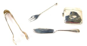 A George V silver vesta case, Birmingham 1943, bearing the initials JAC, a silver butter knife, a pair of Victorian silver shell capped sugar tongs, and a silver pickle fork with twist stem and bobble end, 2&frac14;oz. (4)