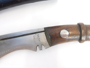 A curved Kukri dagger, marked TD with military arrows and two miniature blades, in a leather scabbard, 45cm wide. - 2