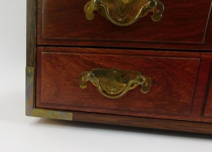 An Eastern hardwood jewellery cabinet, with four long drawers, brass handles and supports, 30cm high, 36cm wide, 23cm deep. - 4