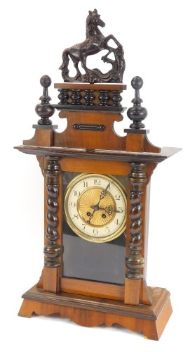An early 20thC walnut mantel clock, with Vienna style fret moulded horse top, brass and ceramic numeric dial, 72cm high, 31cm wide, 15cm deep.