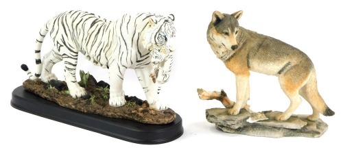 A Country Artist figure of a white tiger, on a black base, 22cm high, 36cm wide, boxed, and a further model of wolf, 22cm high. (2)