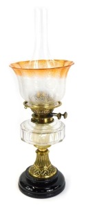 A 19thC brass oil lamp, with an orange and butterfly floral shade, marked Spink and Sons, 38cm high.