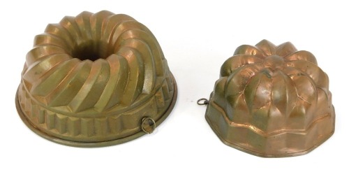 Two copper jelly moulds, a round fluted topped example, 23cm diameter, and a flower topped octagonal jelly mould, 17.5cm diameter. (2)