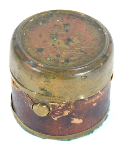 An early 20thC travelling inkwell, with brass domed top and red leather outer support with glass inkwell inserts, 4.5cm high.