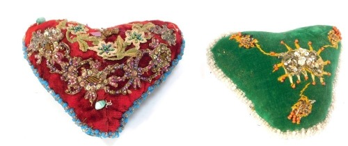 Two needlework sweetheart pin cushions, red and green ground with applied sequin detail, 10cm and 9cm high respectively. (2)