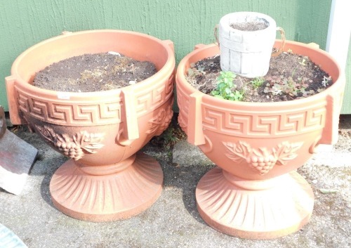 A pair of plastic urn planters, each with Greek key border and berry pattern, 55cm high, 58cm diameter and a stone pot. (3)
