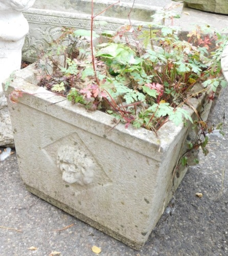 A reconstituted stone planter, square set with lion mask handles, 30cm high, the top 40cm x 40cm.