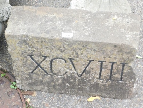A section of stone Roman numerals, marked XCVII (98), 30cm high, 45cm wide, 15cm deep.