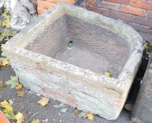 A stone corner trough, demi lune shaped, 42cm high, 76cm wide, 58cm deep.
